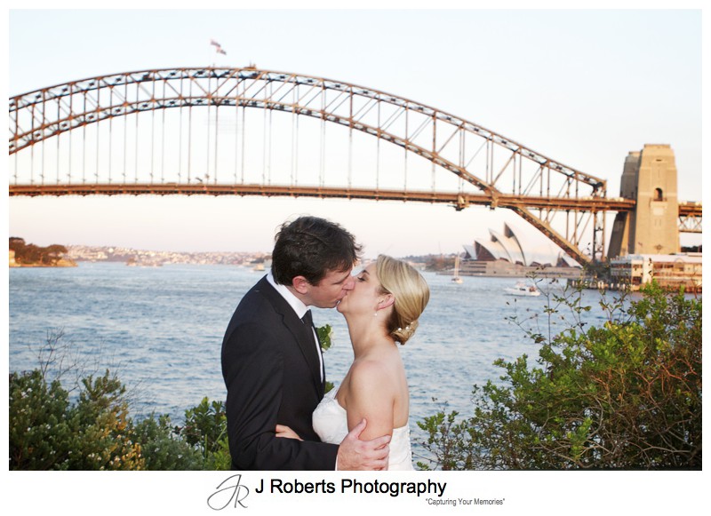 Couple kissing with Sydney Harbour Bridge from Blues Point Reserve - wedding photography sydney